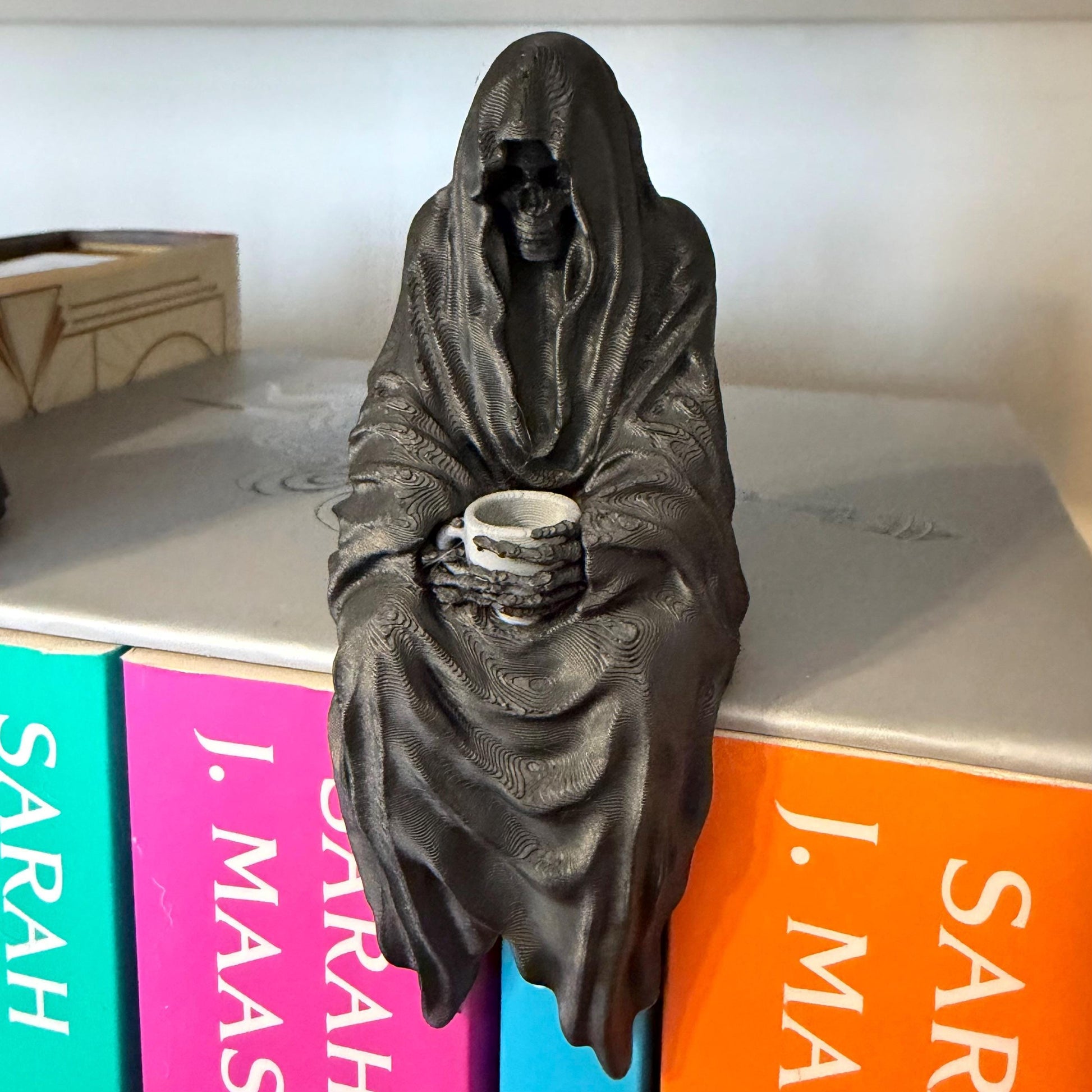 ACOTAR inspired Suriel with tea mug 3d printed shelf sitter, as seen in black and white color option.