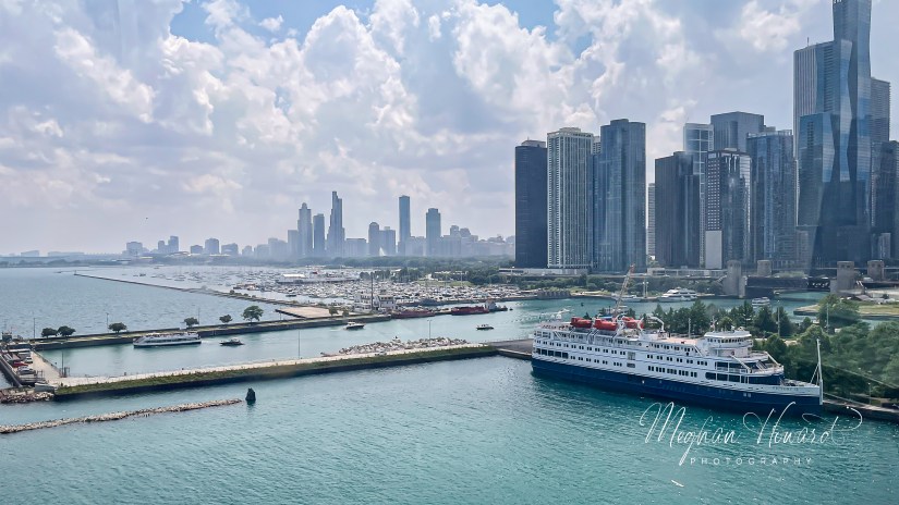 Sweeping view of Chicago’s skyline, Lake Michigan, and marina from the top of the Navy Pier Ferris Wheel, with tour boats and the ship Victory II docked below.