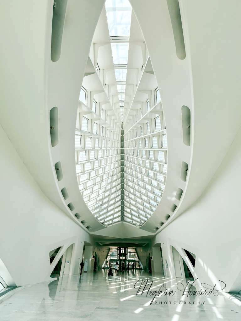 Interior of the Milwaukee Art Museum, showing its futuristic white architecture and glass ceiling.