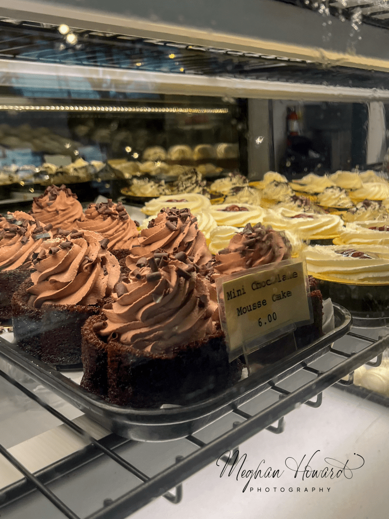 Dessert display case at Milwaukee Public Market with chocolate mousse cakes and pastries.