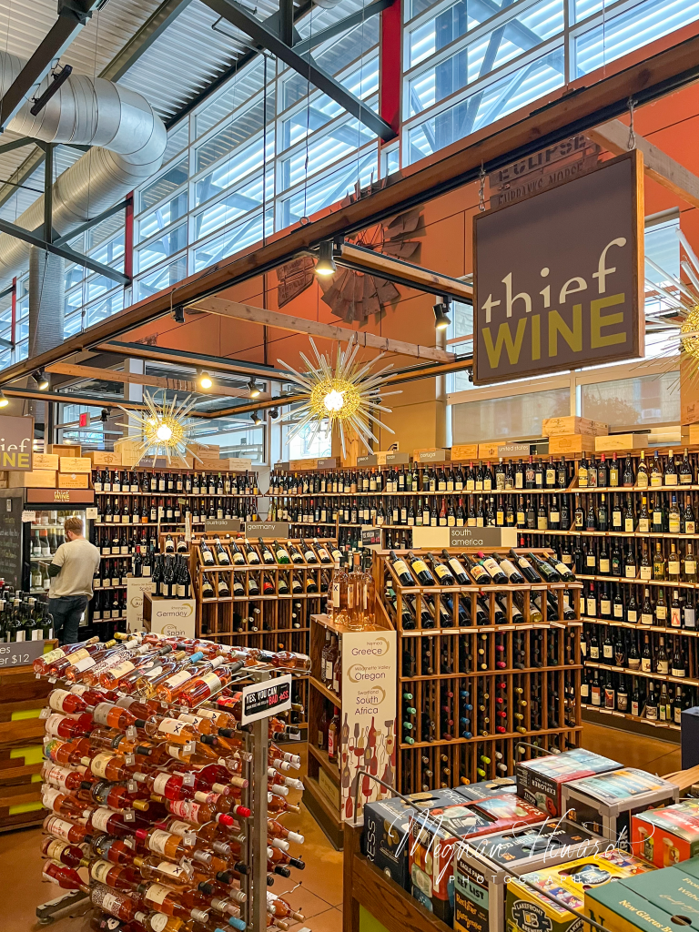 Wine shop inside Milwaukee Public Market with rows of bottles and signage.