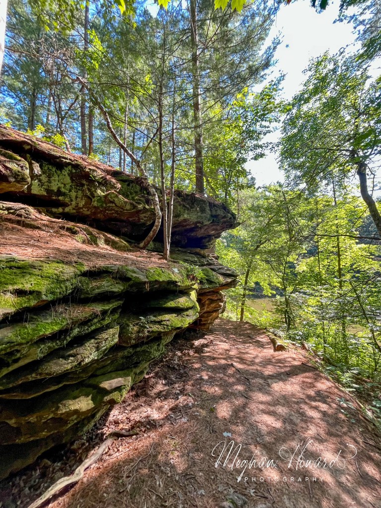 Echo Rock sandstone cliff rising above the forest trail at Mirror Lake State Park in Wisconsin