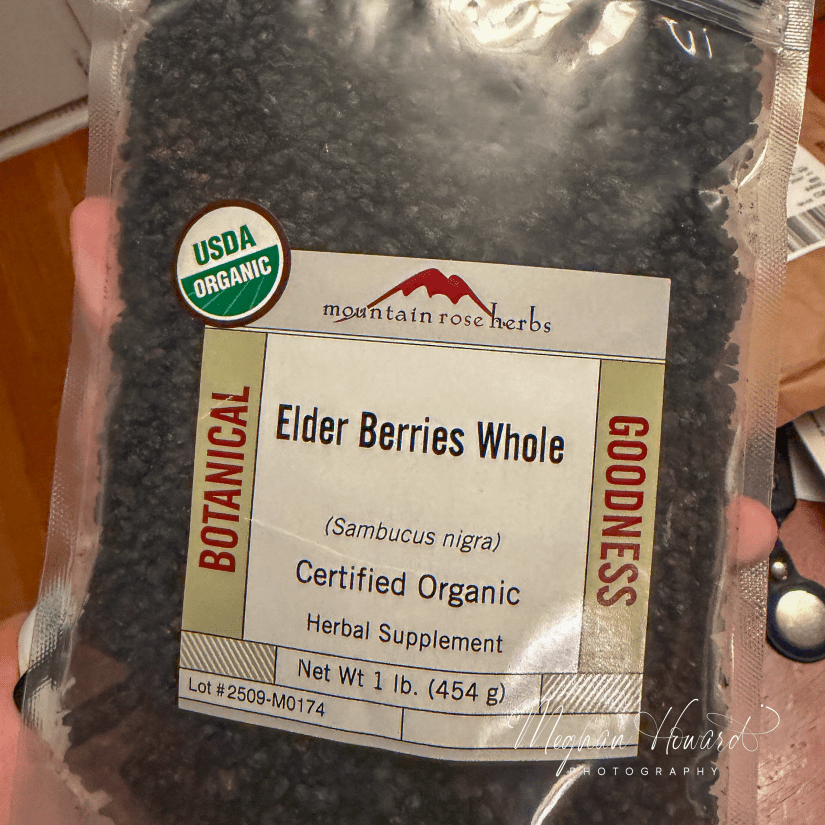 Bag of Mountain Rose Herbs certified organic elderberries held in hand, showing label and USDA Organic seal.