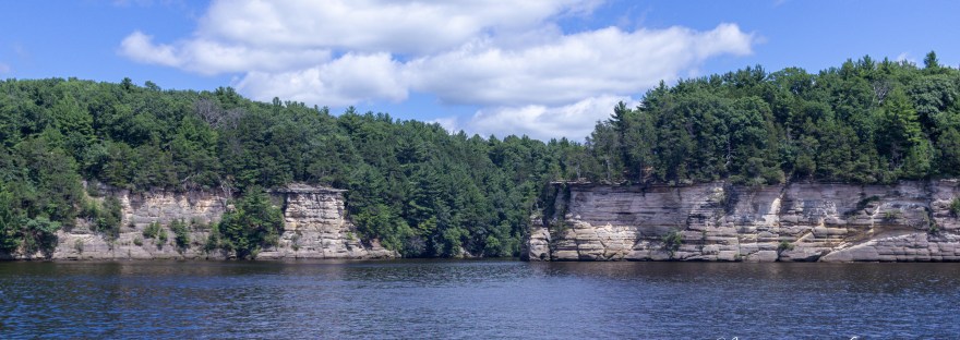 Scenic sandstone cliffs rising above the Wisconsin River in the Upper Dells on a sunny summer day